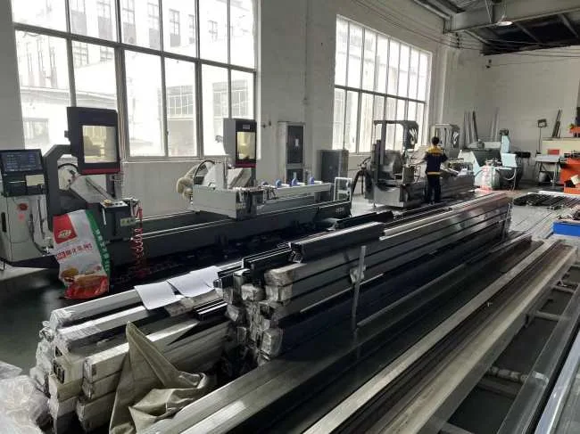 Aluminum profiles and machining equipment in the KEST Door production area.